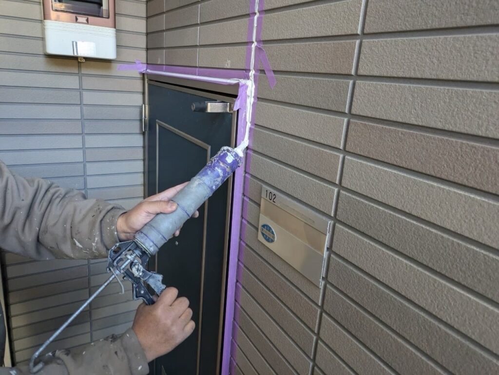 玄関のコーキングを施工している様子