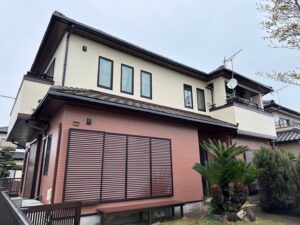 外壁をベージュとベージュピンクに塗装された一軒家
